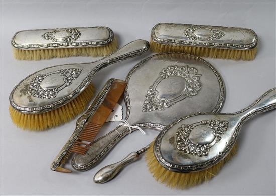A George V silver mounted six piece brush and mirror set and a silver mounted button hook.